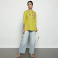 Woman wearing a yellow embroidered cotton tunic top with three-quarter sleeves